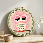 Cute pink owl punch needle artwork displayed on a table