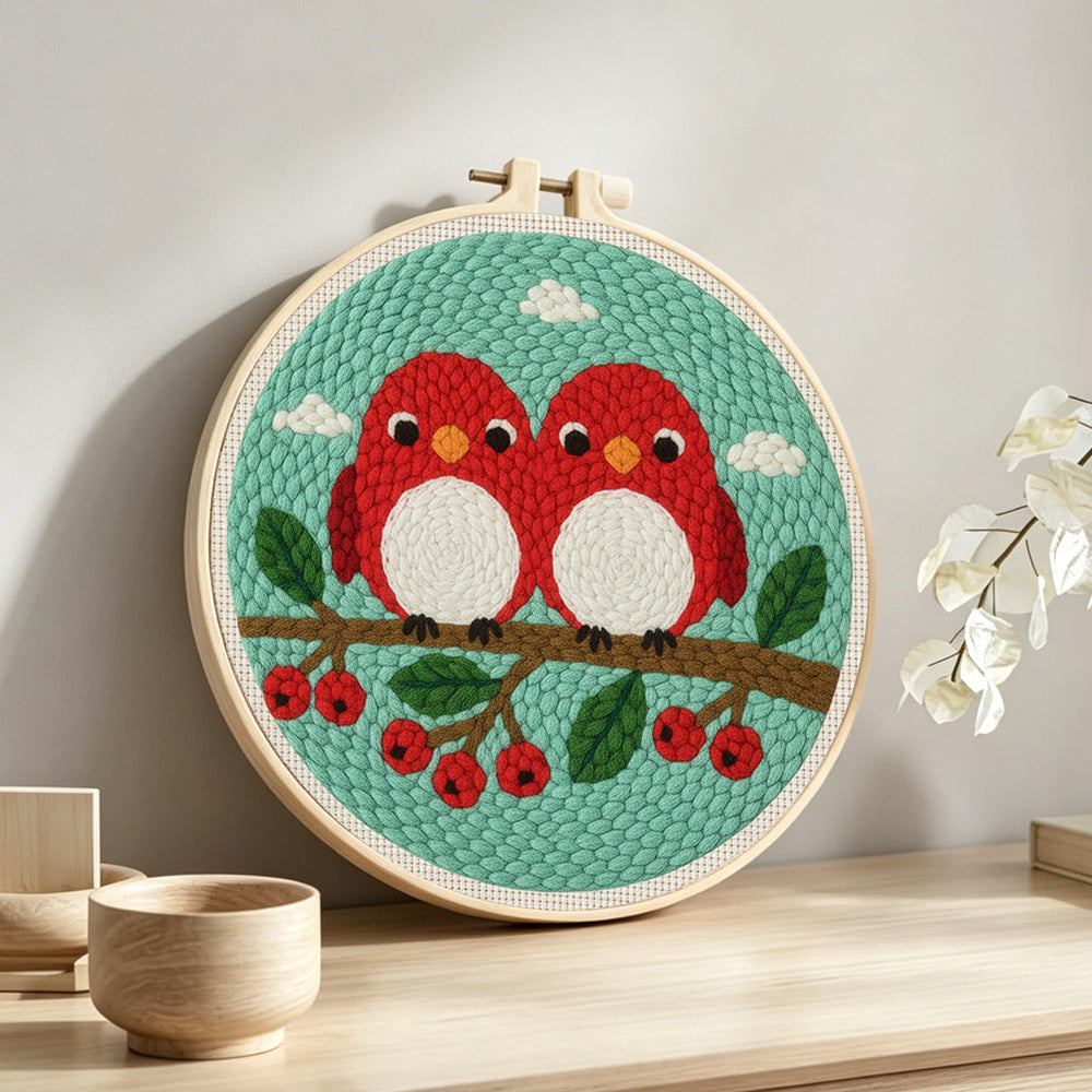 Cute red birds on berry branch punch needle artwork displayed on a table