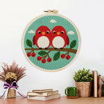 Finished cute red birds on berry branch artwork displayed on a wall