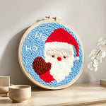 Cute santa claus “ho ho” punch needle artwork displayed on a table