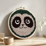 Cute sloth face punch needle artwork displayed on a table