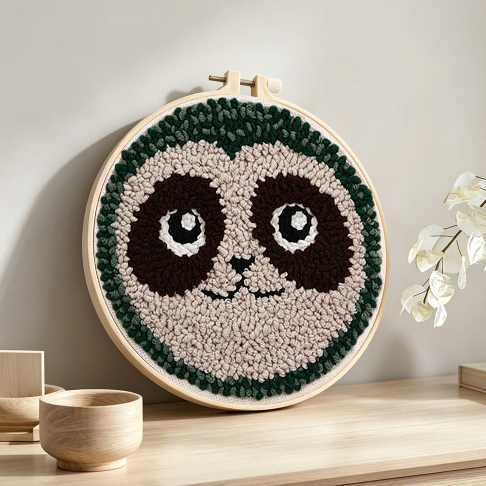Cute sloth face punch needle artwork displayed on a table