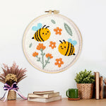 Finished cute smiling bumblebees and orange flowers artwork displayed on a wall