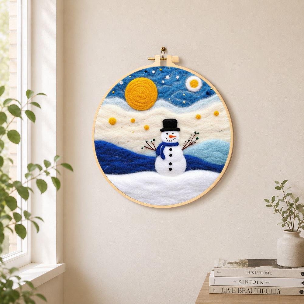 Cute snowman under the full moon needle felt wall art displayed in a bright home interior
