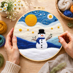 Creating the cute snowman under the full moon wool painting by hand with a felting needle