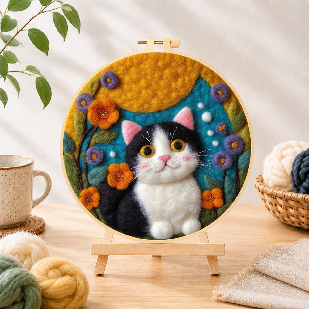 Finished cute tuxedo cat and bright flowers needle felting displayed on a wooden easel