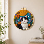 Cute tuxedo cat and bright flowers needle felt wall art displayed in a bright home interior