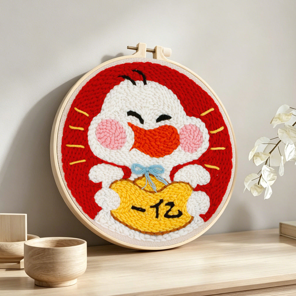 Cute white duck holding lucky gold bag punch needle artwork displayed on a table
