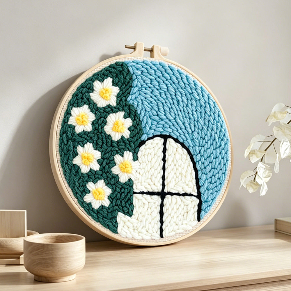Cute window view with white flowers punch needle artwork displayed on a table