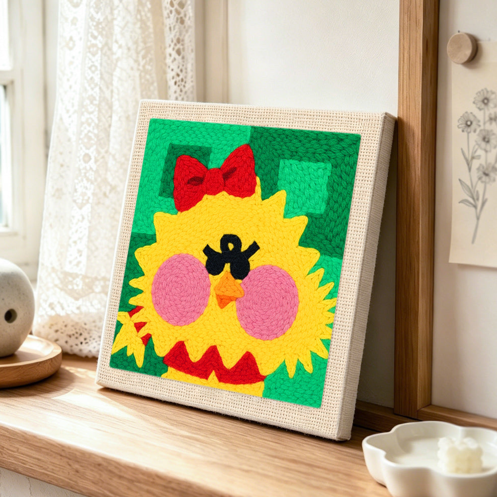 Cute yellow chick punch needle artwork displayed on a table