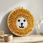 Cute yellow lion face punch needle artwork displayed on a table