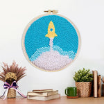 Finished cute yellow rocket launch artwork displayed on a wall
