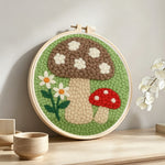 Daisies and mushrooms punch needle artwork displayed on a table