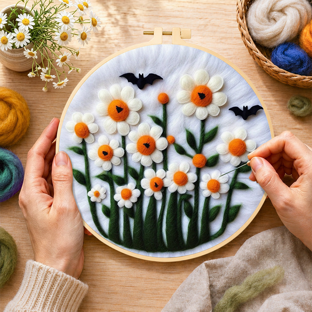 Creating the daisies with bats on white wool painting by hand with a felting needle