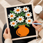 Creating handmade daisy flowers in orange vase punch needle artwork