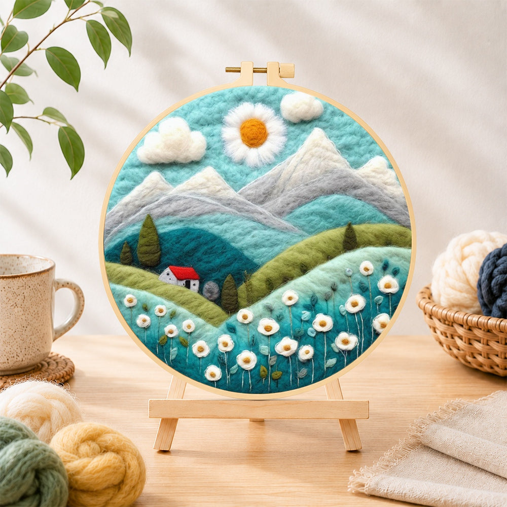 Finished daisy sun and red cottage in the alps needle felting displayed on a wooden easel