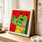 Dapper crocodile with bow tie punch needle artwork displayed on a table