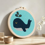 Dark blue whale punch needle artwork displayed on a table