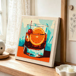 Dark cocktail with cherry and orange punch needle artwork displayed on a table