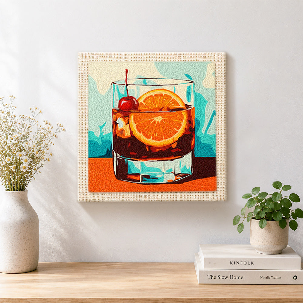 Finished dark cocktail with cherry and orange artwork displayed on a wall