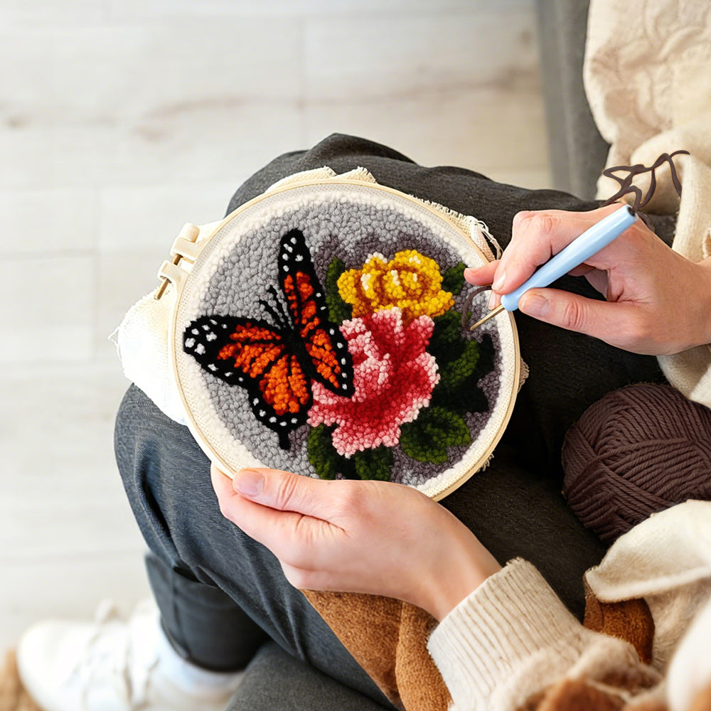 Creating handmade dark-coloured butterfly and flowers punch needle artwork