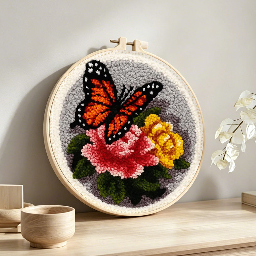 Dark-coloured butterfly and flowers punch needle artwork displayed on a table