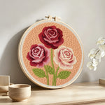 Deep pink and cream roses punch needle artwork displayed on a table