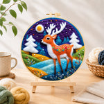 Finished deer with white antlers in purple night needle felting displayed on a wooden easel