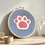 Dog paw print punch needle artwork displayed on a table