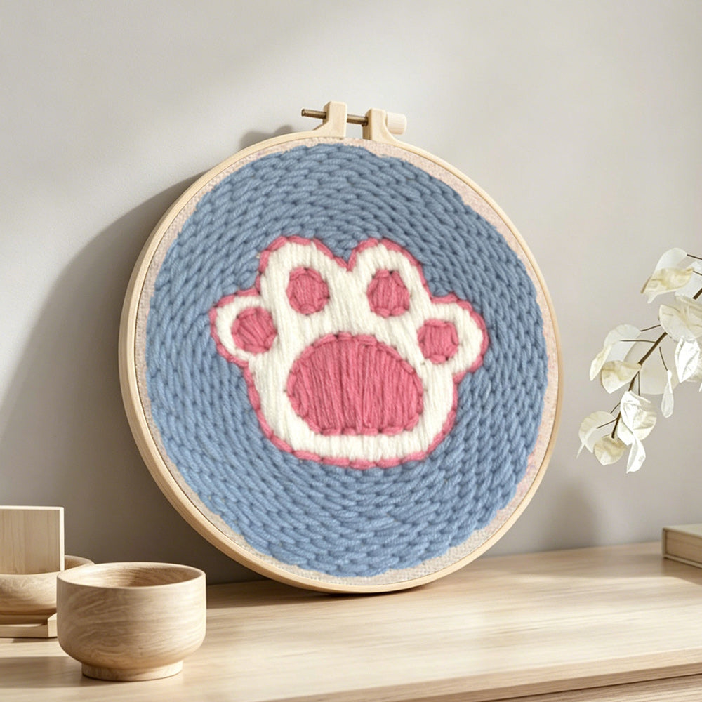 Dog paw print punch needle artwork displayed on a table