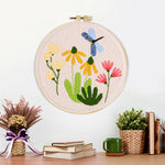 Finished dragonfly and garden wildflowers artwork displayed on a wall