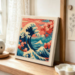 Dramatic waves and cherry blossoms punch needle artwork displayed on a table