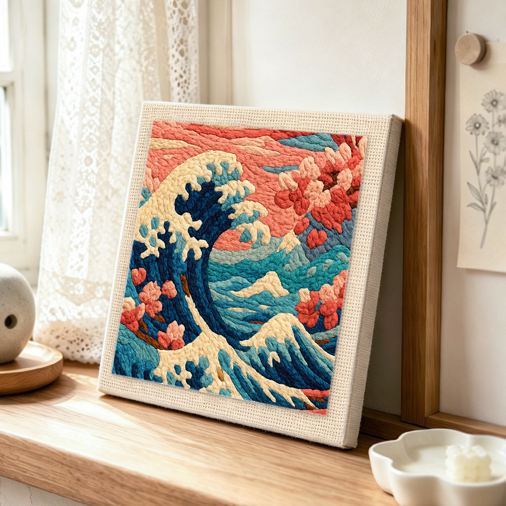 Dramatic waves and cherry blossoms punch needle artwork displayed on a table