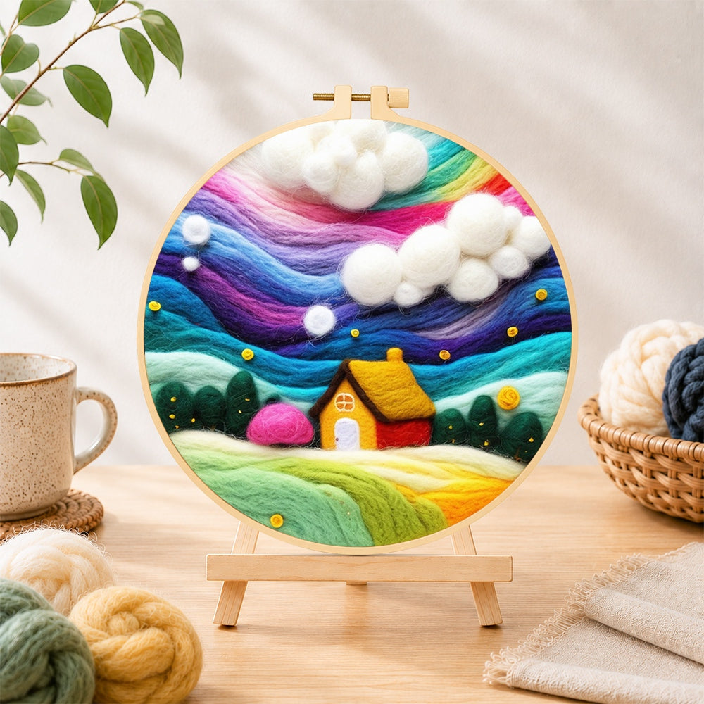 Finished dreamy cottage under the rainbow aurora needle felting displayed on a wooden easel