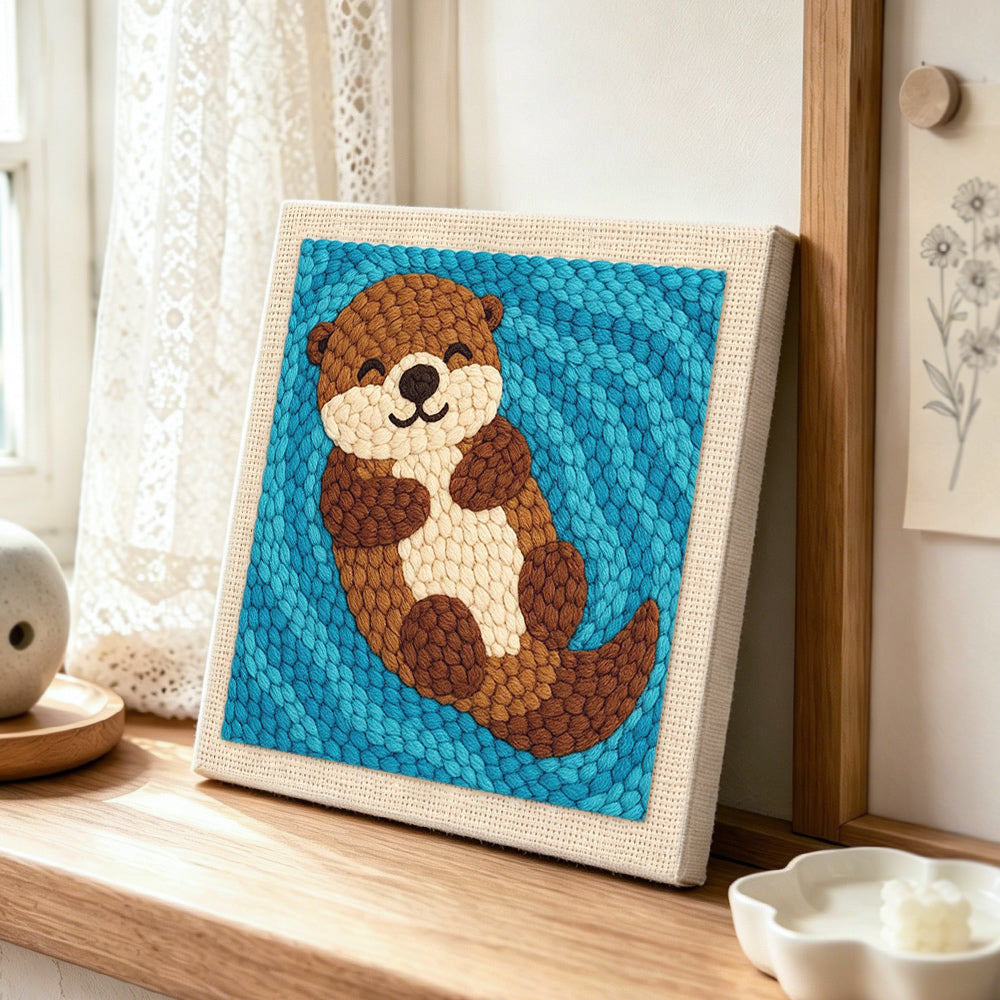 Dreamy swimming otter punch needle artwork displayed on a table