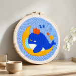 Dreamy whale and moon punch needle artwork displayed on a table