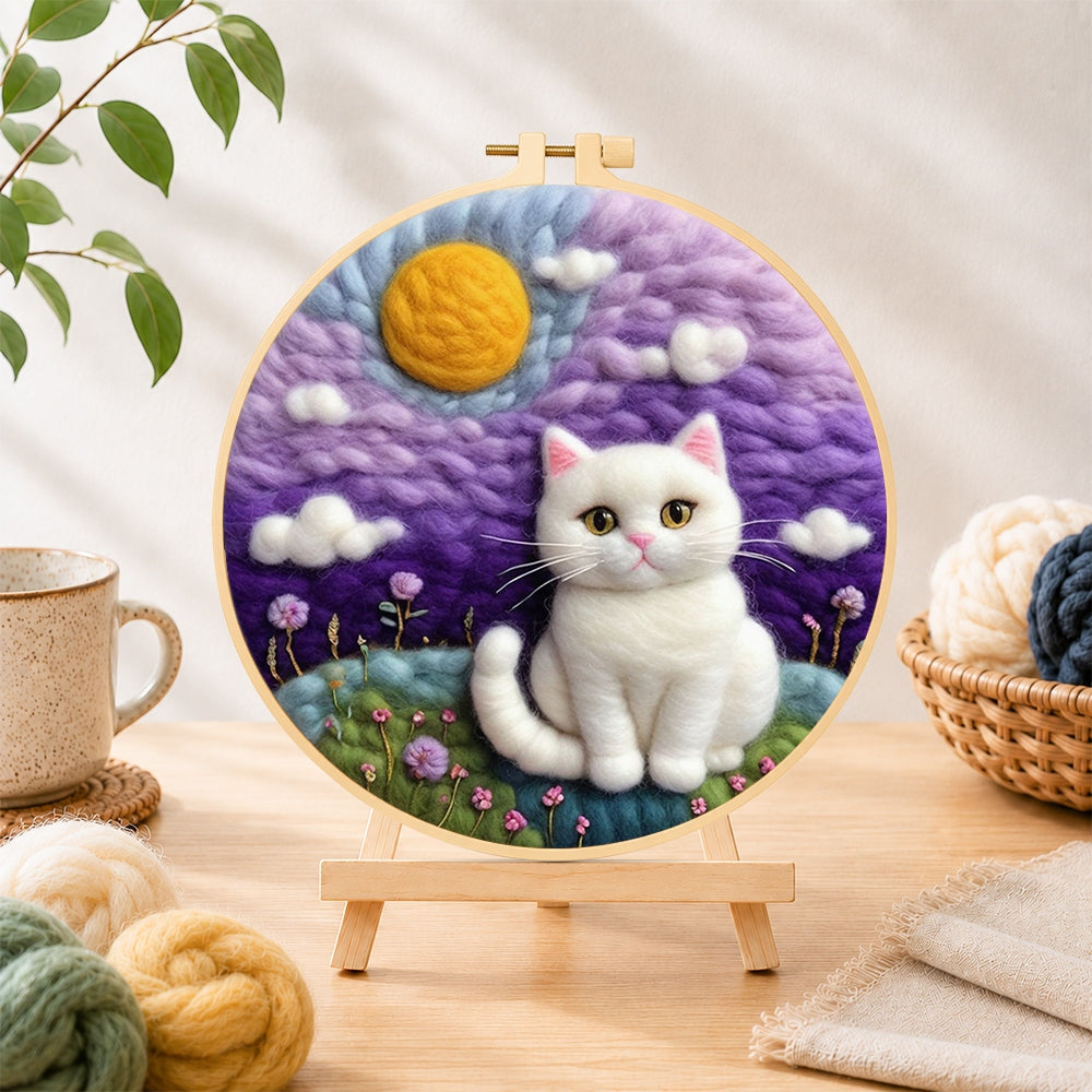 Finished dreamy white cat in purple clouds needle felting displayed on a wooden easel