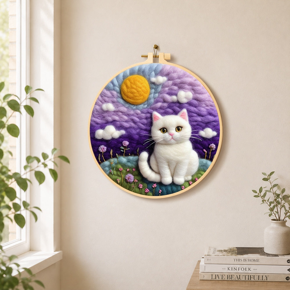 Dreamy white cat in purple clouds needle felt wall art displayed in a bright home interior