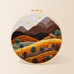 Earthy brown and burnt orange mountains with trees needle felting kit for beginners with a round wooden frame