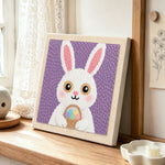 Easter bunny with egg basket punch needle artwork displayed on a table