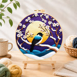 Finished elegant blue bird on snowy plum branch needle felting displayed on a wooden easel