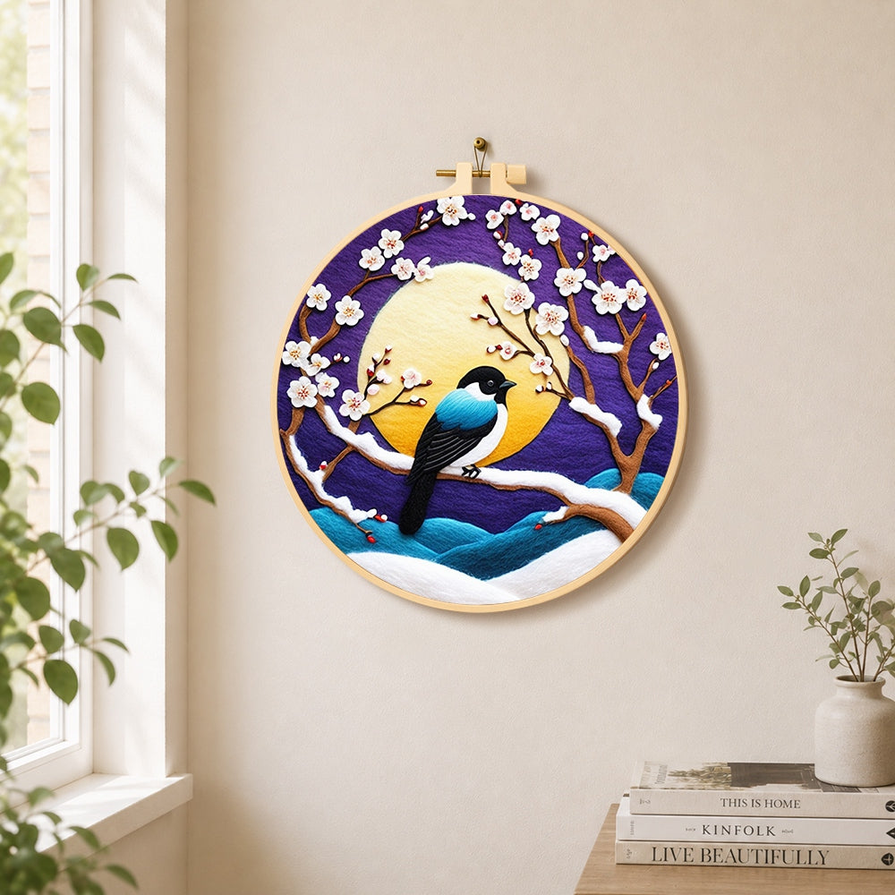 Elegant blue bird on snowy plum branch needle felt wall art displayed in a bright home interior
