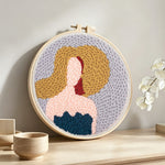Elegant lady with fashion hat punch needle artwork displayed on a table