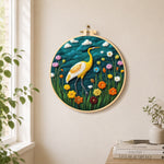 Elegant yellow heron among flowers needle felt wall art displayed in a bright home interior