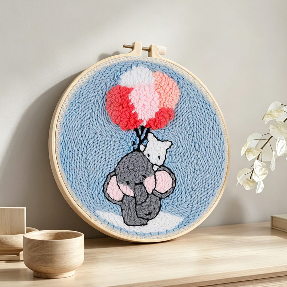 Elephant with balloons punch needle artwork displayed on a table
