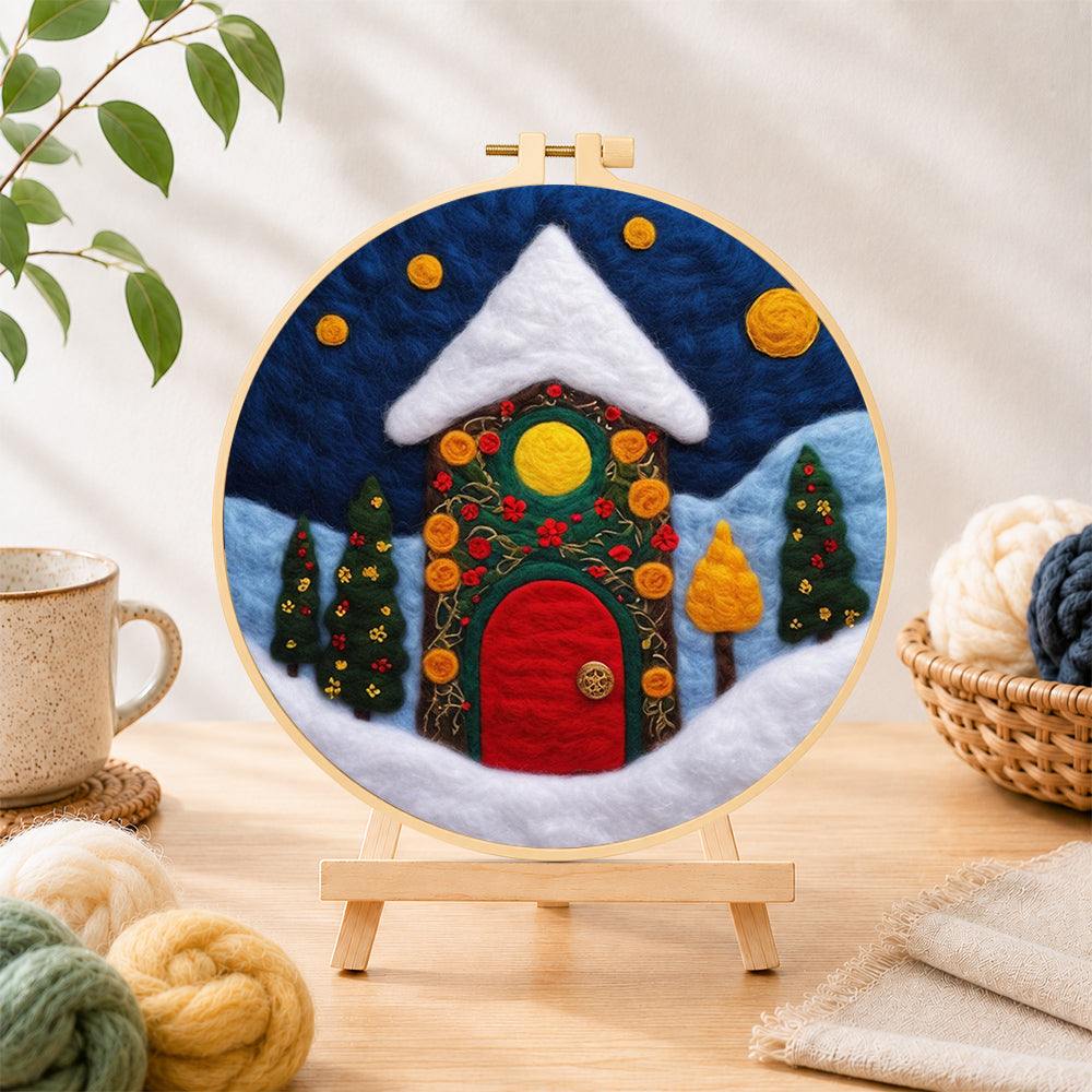 Finished enchanted cottage with red door and vines needle felting displayed on a wooden easel