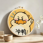 Encouraging cartoon duck punch needle artwork displayed on a table