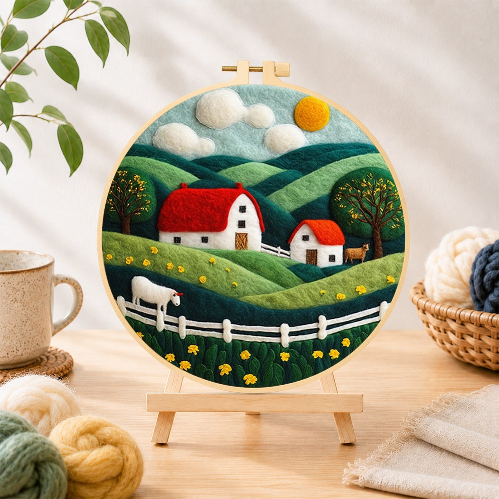 Finished english cottage and rolling hills needle felting displayed on a wooden easel