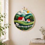 English cottage and rolling hills needle felt wall art displayed in a bright home interior