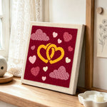 Entwined yellow hearts punch needle artwork displayed on a table